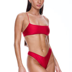 Woman wearing a red bikini set on a white background