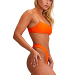 Woman wearing an orange bikini on a white background
