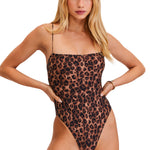 Woman wearing a leopard print swimsuit on a white background